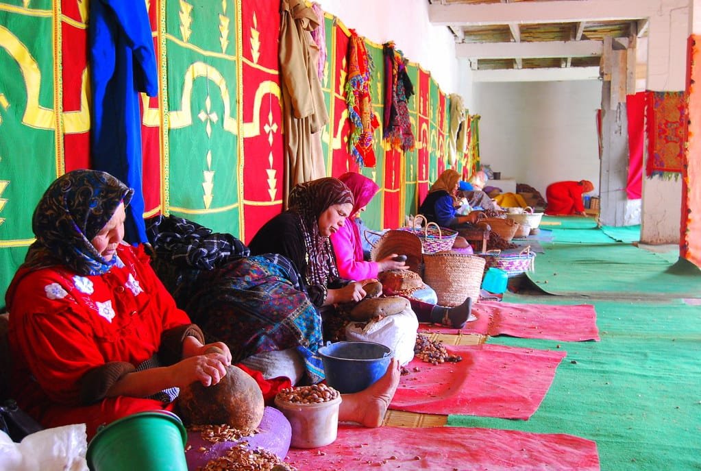 Women at an argan oil cooperative in Morocco handcrafting argan products using traditional techniques