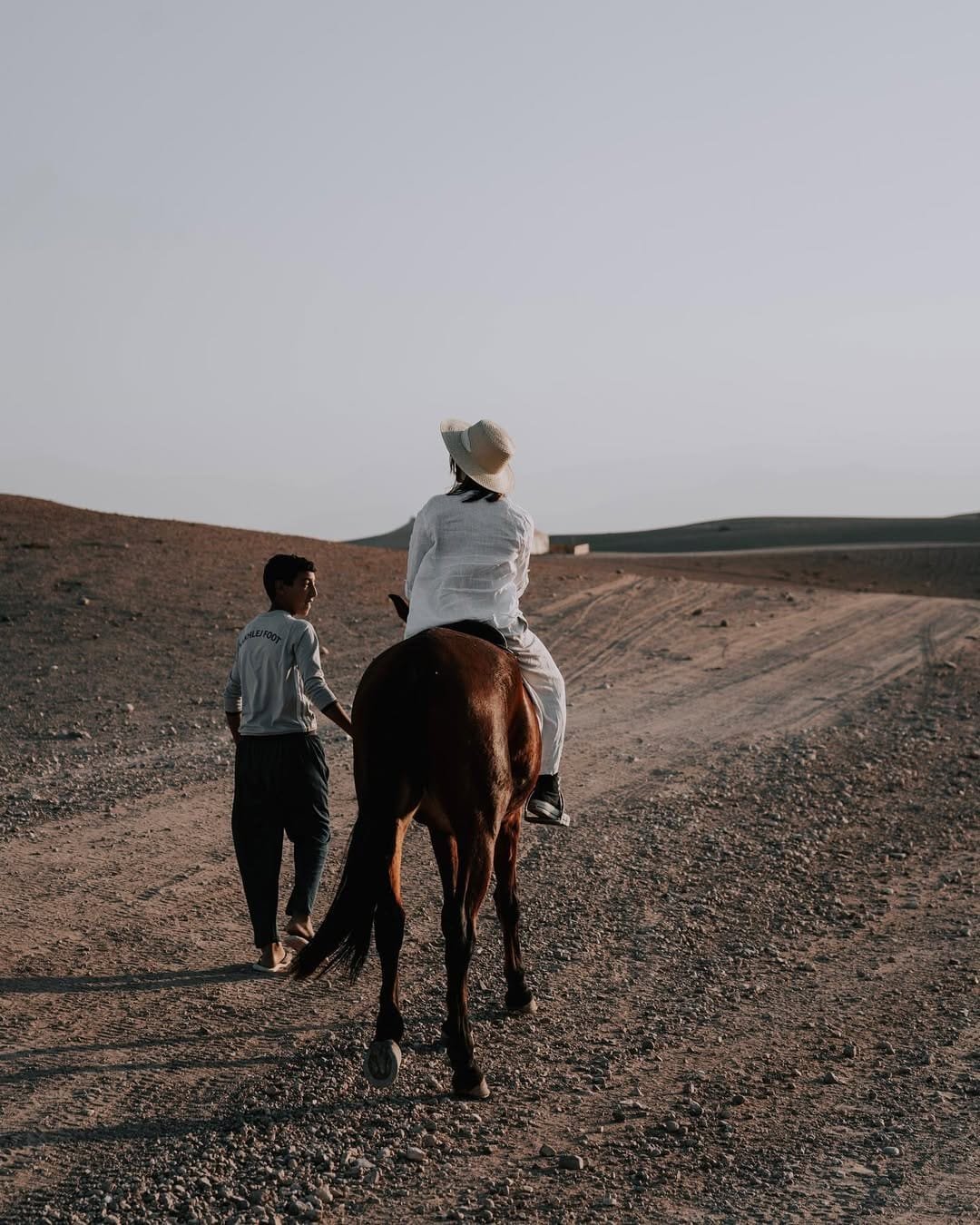 Woman riding a horse through the Moroccan desert landscape, experiencing traditional desert adventure