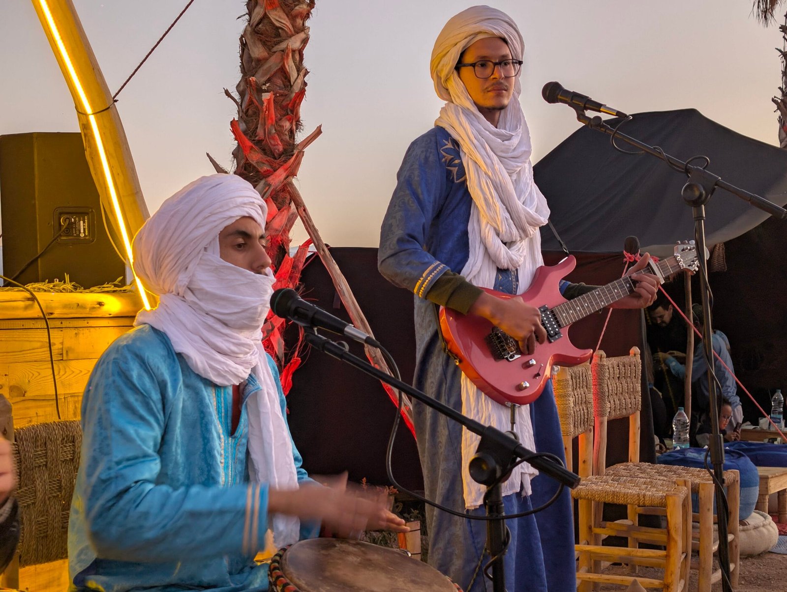 Two Berber musicians performing traditional music to preserve and share their culture during a Moroccan desert experience