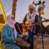 Two Berber musicians performing traditional music to preserve and share their culture during a Moroccan desert experience