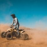 Tourist riding a quad bike through the rocky trails of the Agafay Desert near Marrakech