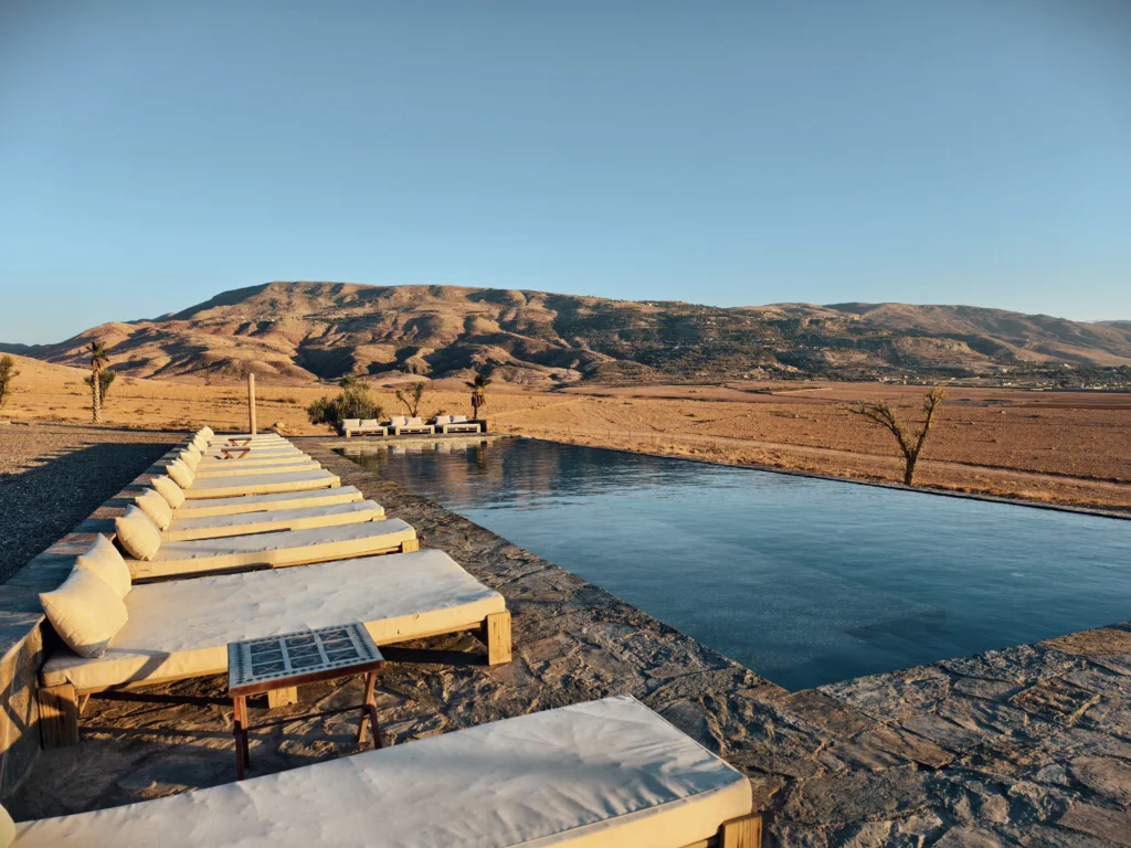 Book an Agafay Desert package with 1-hour camel ride or quad ride, Moroccan fixed menu, live music band, fire show, and optional transport.