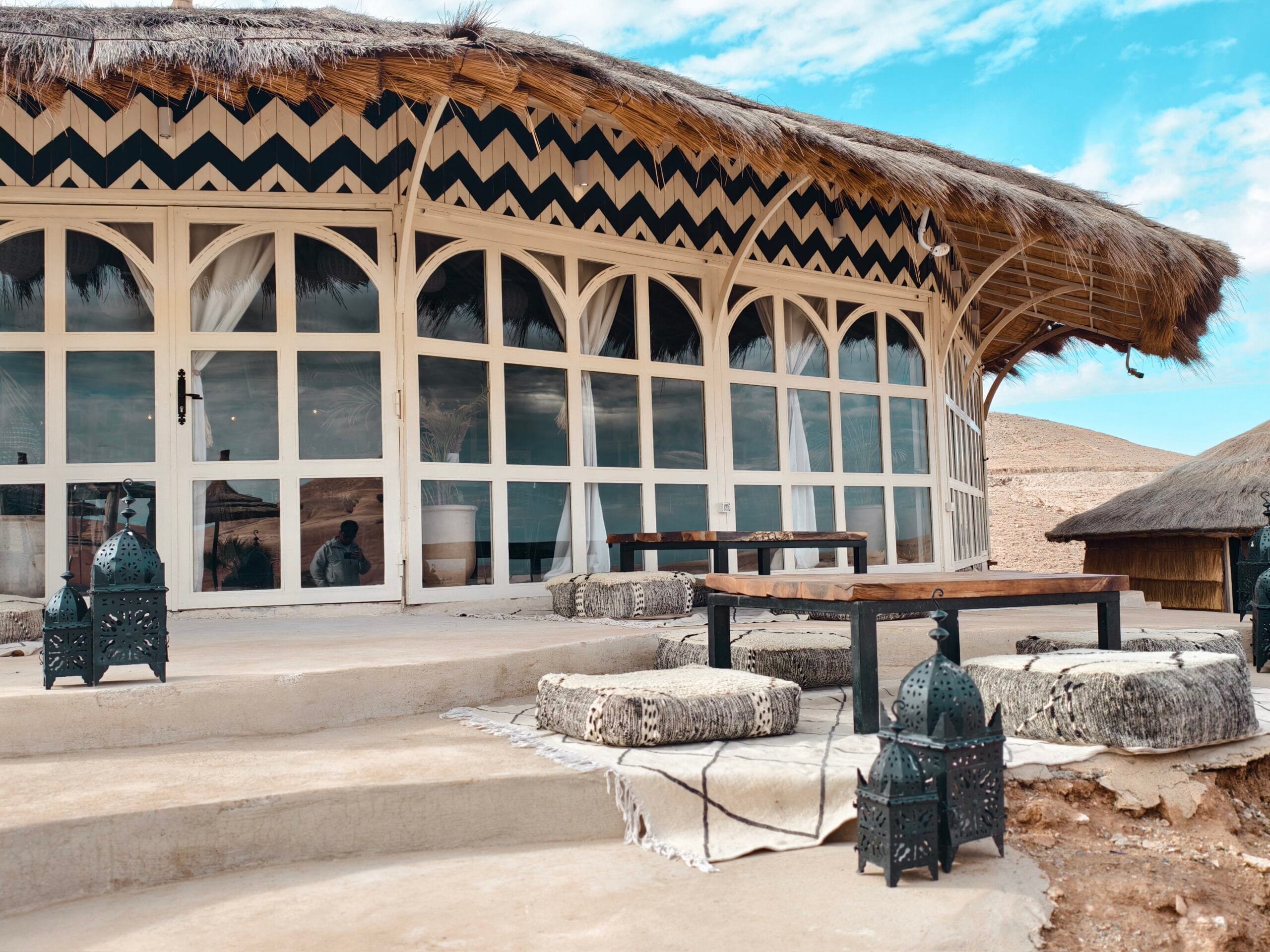 The main building at Be Agafay with arched windows and a thatched roof