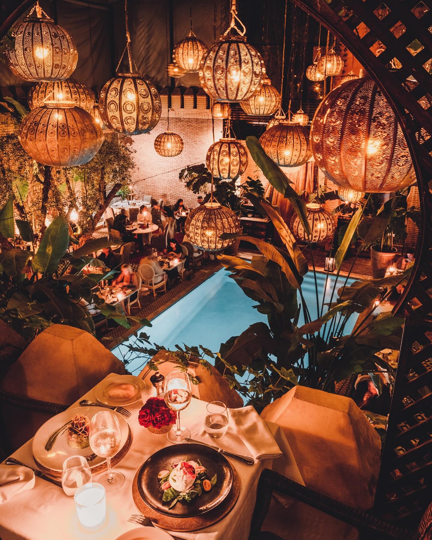 La Trattoria Marrakech romantic outdoor dining by the pool with candlelit tables and Moroccan lanterns