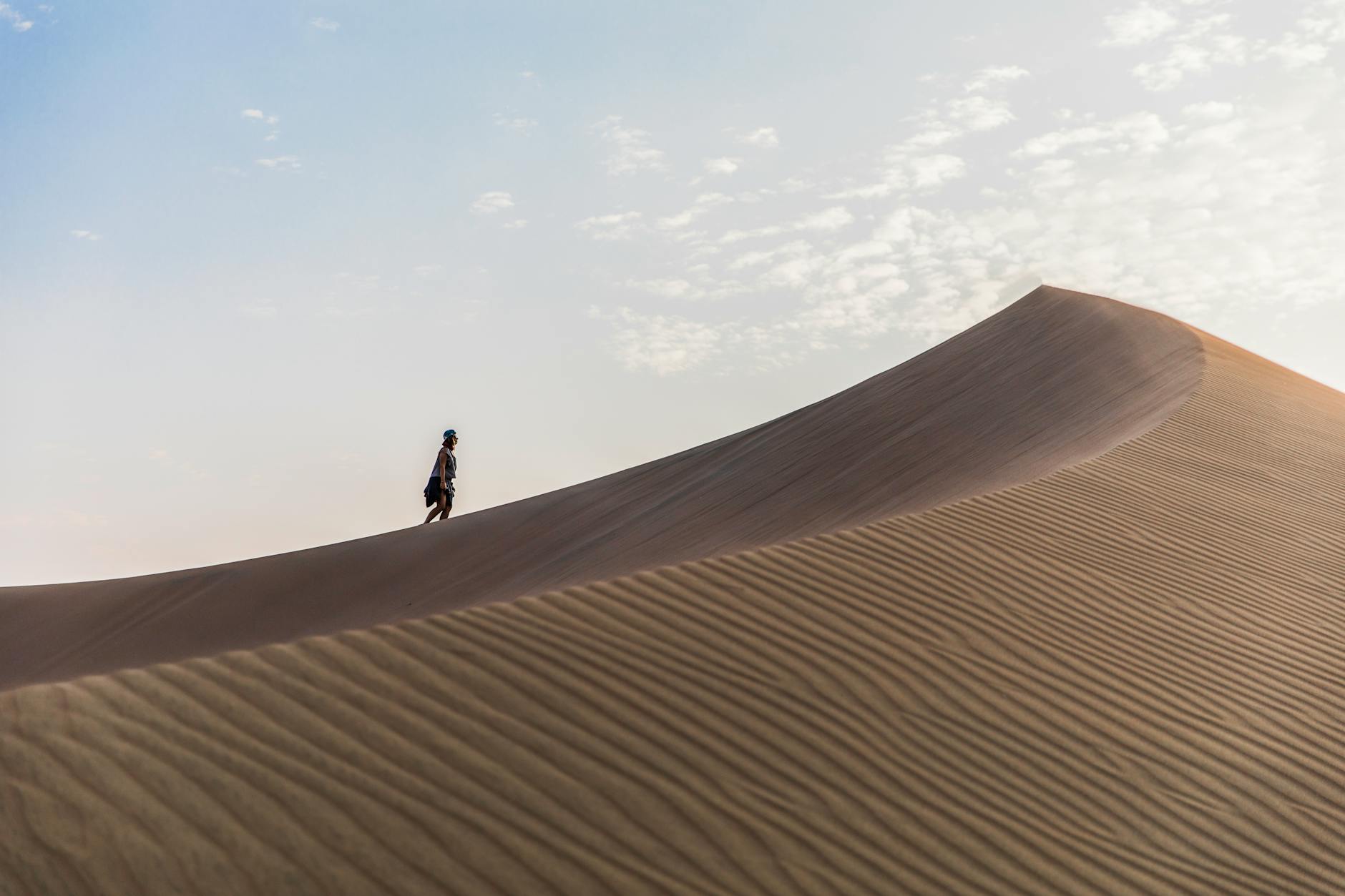 A panoramic view of the rocky hills in the Agafay desert under a sunset sky, answering the question: Does Agafay desert have sand dunes?