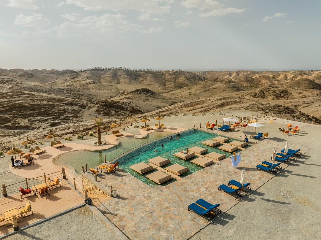 A stunning Agafay desert luxury camp with private pool overlooking the Atlas Mountains at sunset