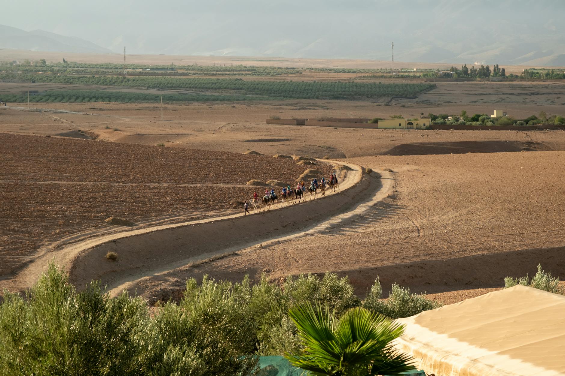 A beautiful sunset over the rocky hills of the Marrakesh Desert with traditional Berber tents.