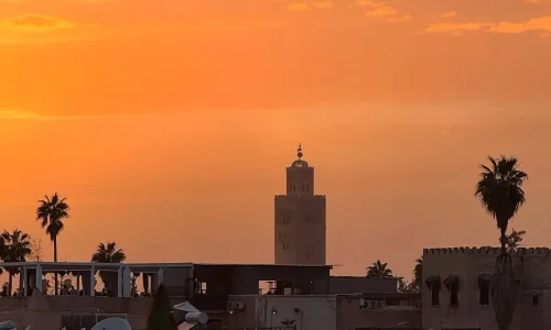 1000043005 Stunning sunset view of Marrakech skyline with historic mosque minaret and traditional buildings